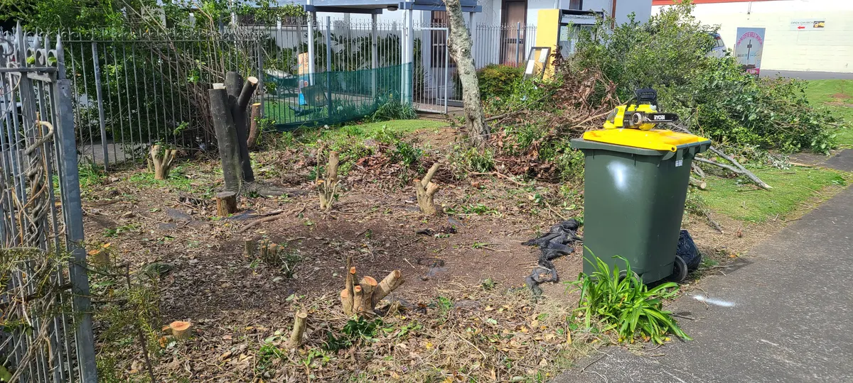 Overgrown garden cleared back to the ground by Jay, green waste piled for removal