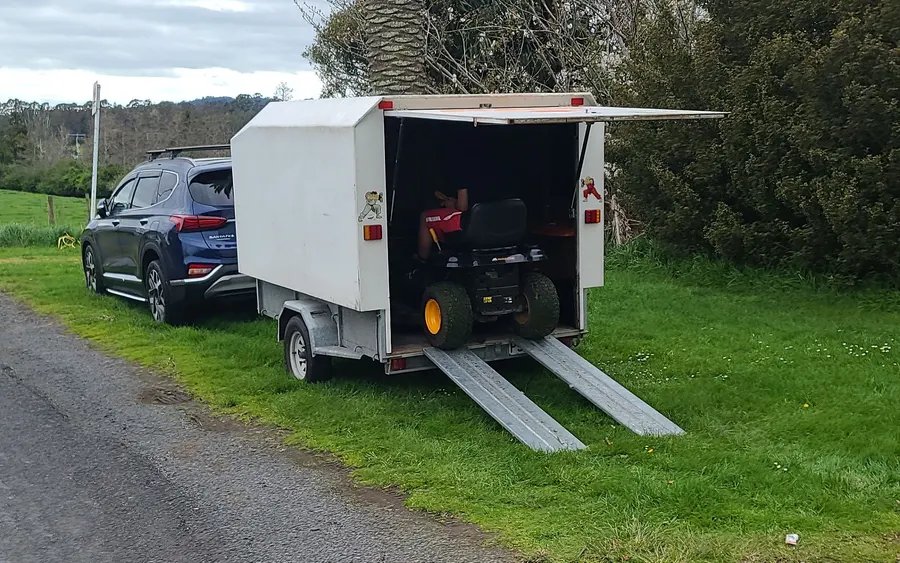 Jay's enclosed trailer with a ride-on mower and loading ramps